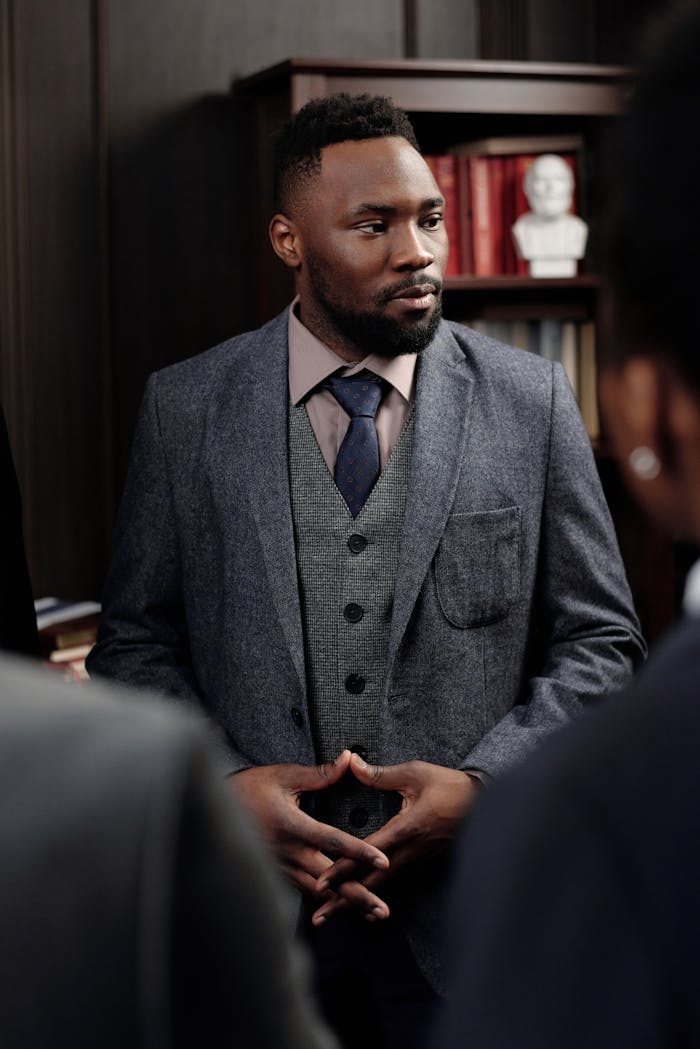 Confident businessman in a suit leading a discussion in a formal office setting.